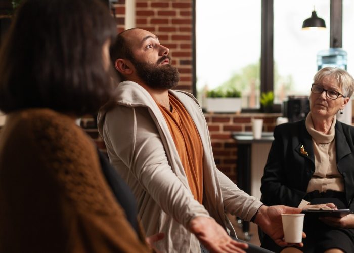 close-up-man-sharing-addiction-issues-with-aa-meeting-group-therapist-person-explaining-anxiety-depression-problems-support-therapy-with-psychiatrist-sitting-circle